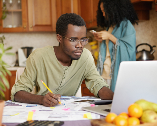 A man working on his finances at a table in the kitchen
